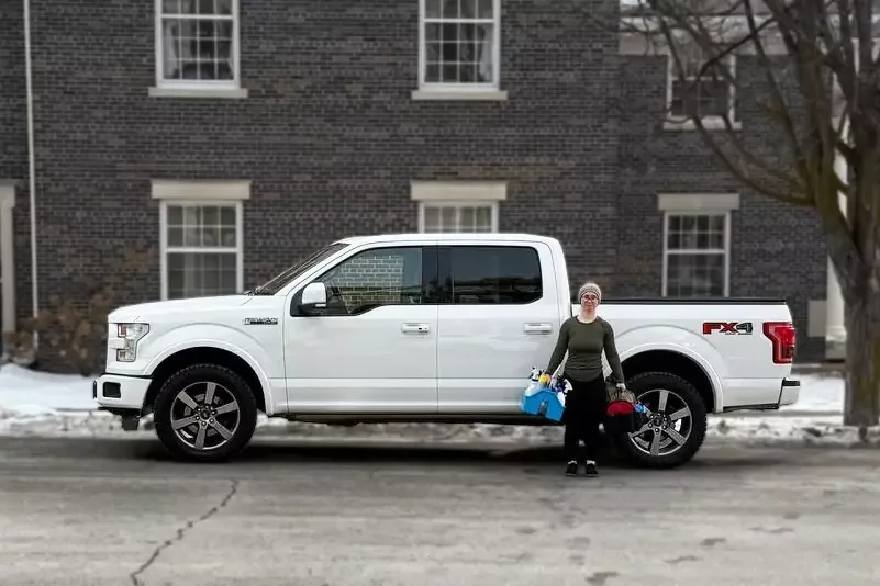 Melinda, co-owner, standing in front of company vehicle